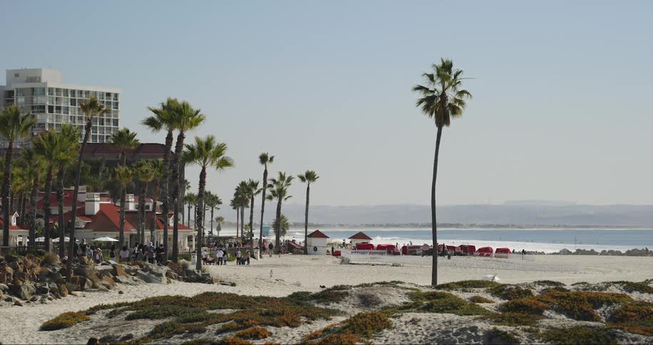 People move around on beach and at nearby hotel as waves roll in