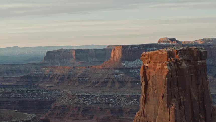 Light snow on the mesas under a cloudy blue sky