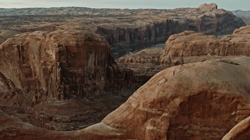 The sun shines on mountain badlands and a deep canyon