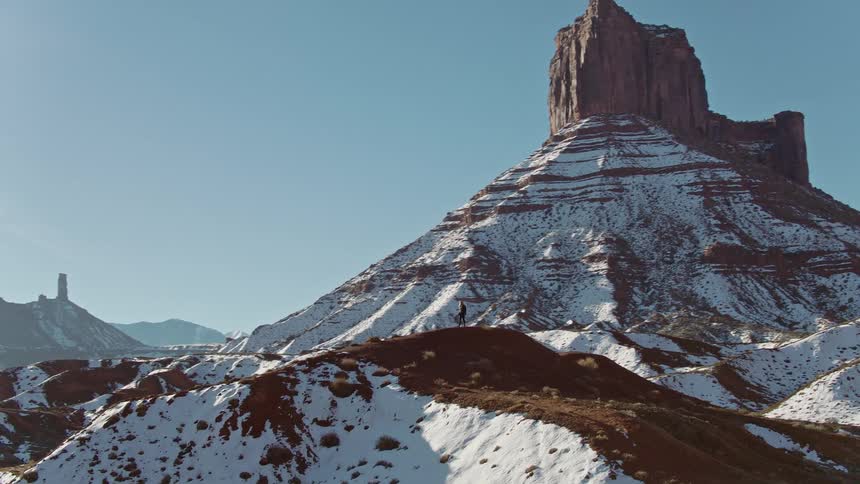 A hiker stands in awe as they behold a massive canyon in the southwest