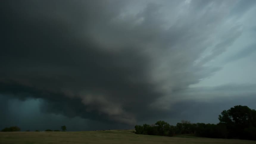 A massive and intense bolt of lightning strikes the ground as a severe thunderstorm barrels across middle american during tornado season