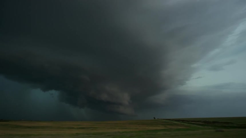 A supercell thunderstorm rotating and rolling over rural america as intense lightning flashes and strikes farmland in this high energy handheld shot