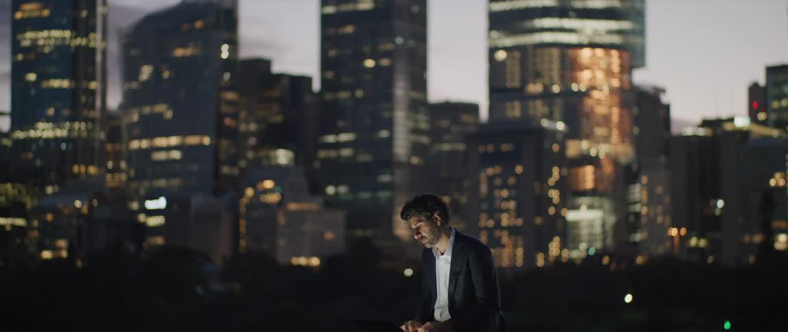 A man is standing before a large city