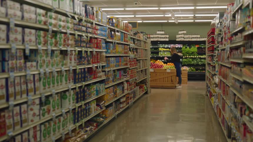 An employee down the aisle is sorting fruit