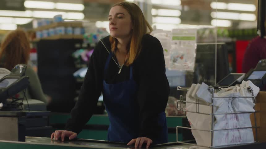 A woman waits for a customer at the register