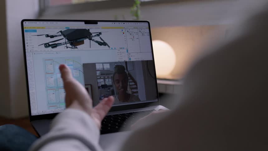 A man is sitting down with his laptop and talking to a woman on video chat online