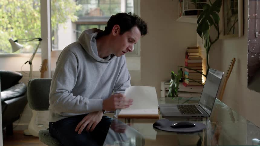 A man is talking on his laptop