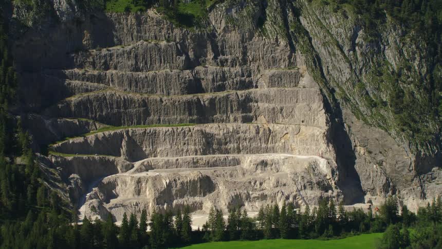 A winding path is carved into the side of a rocky mountain