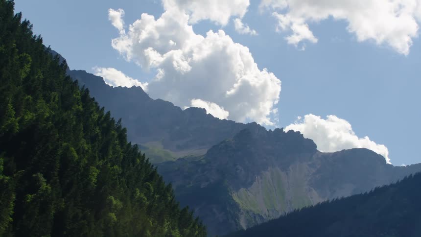 Aerial view of high mountains slopes with forest
