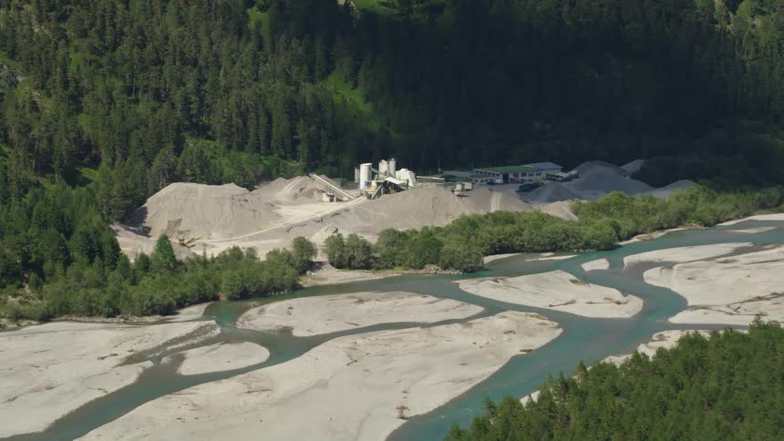 Aerial view of branching river and construction area in the forest