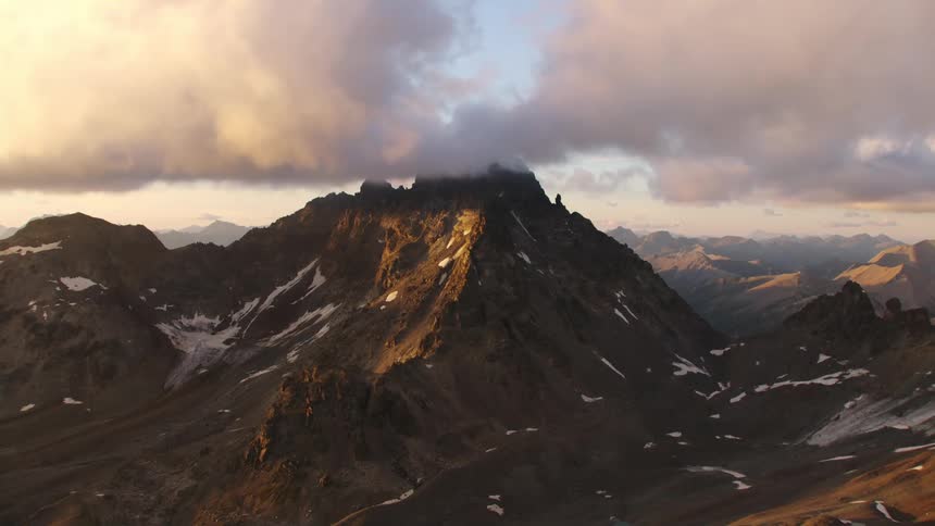Aerial view of steep mountain under clouds at dawn