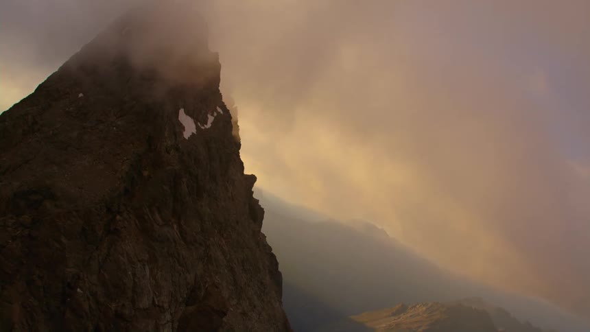 Aerial view of steep mountain under clouds