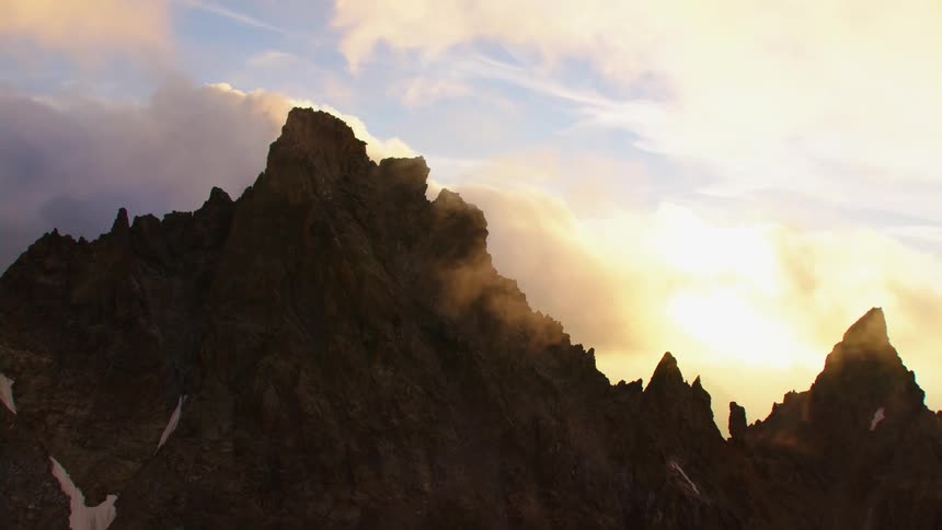 A jagged mountain peak under a cloudy daytime sky