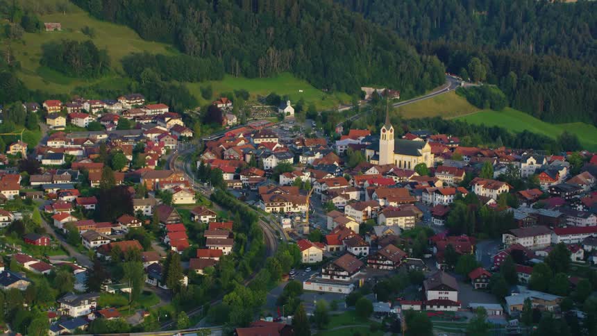 Aerial view of a small town on a valley near a pine tree forest