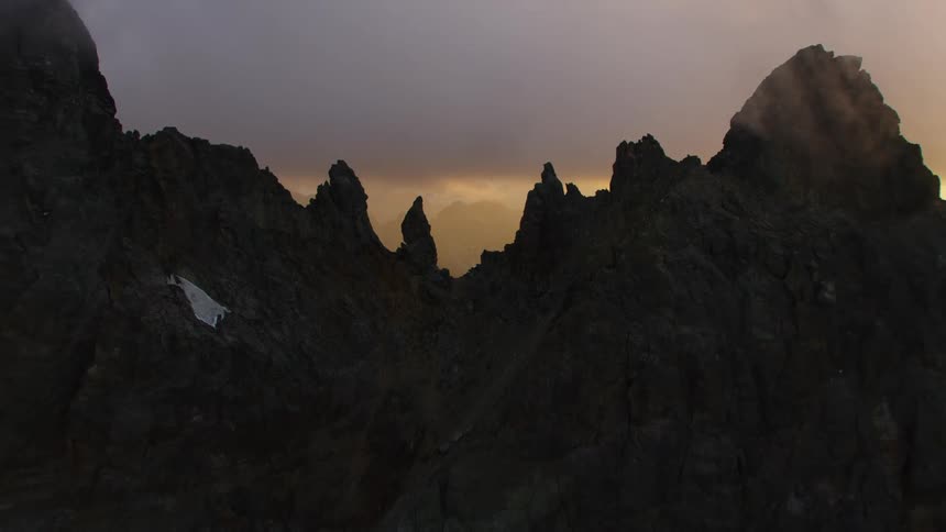A mountain range under a cloudy evening sky