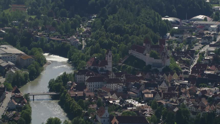 An aerial view of a river running through a neighborhood and a car driving across a bridge