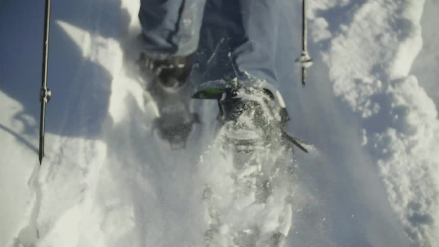 Snowshoe wearing feet trudging through thick snow