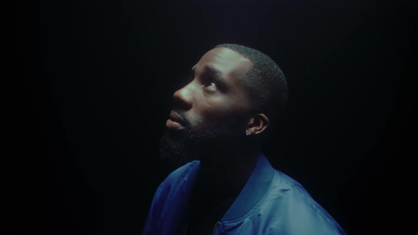 A man looks up while standing in a dark room