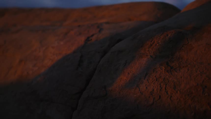 Shadow of a thin woman over a rock at evening