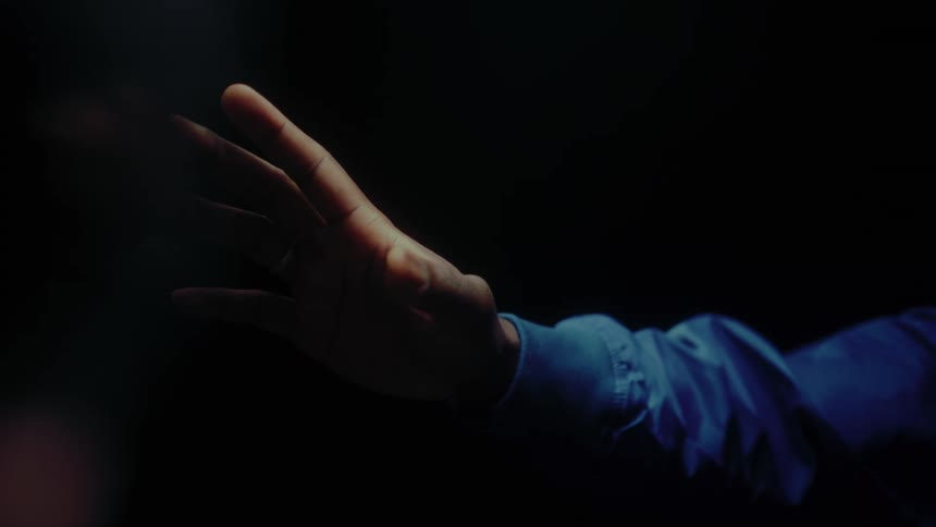 Arm reaches out in the dark