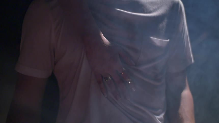 A woman touches a man's chest as he is seated