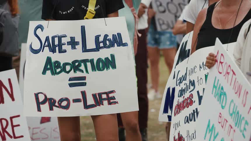 People hold signs at a protest