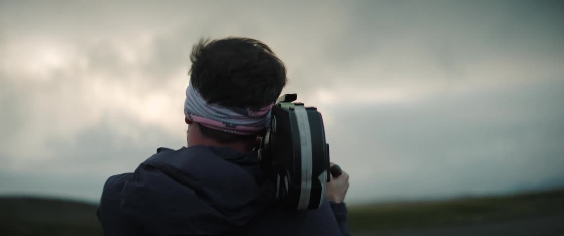 A camera man films a river and landscape