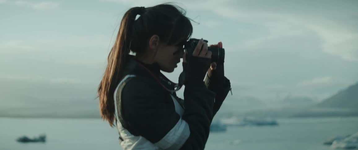 A woman takes photos of icebergs