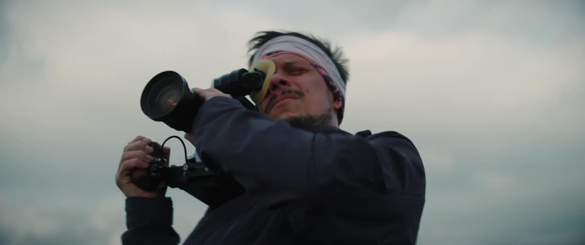A man uses a vintage style camcorder to record video