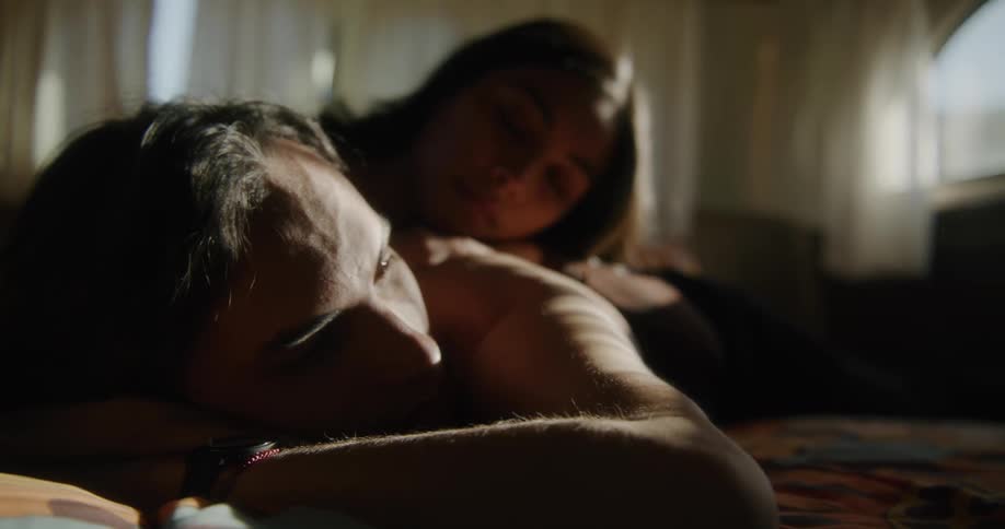 A couple are laying in bed together