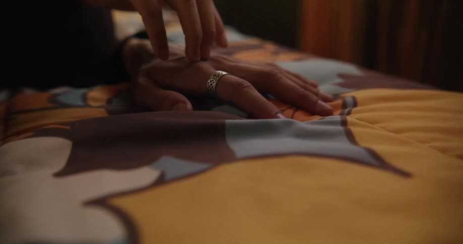 A hand is caressed in bed
