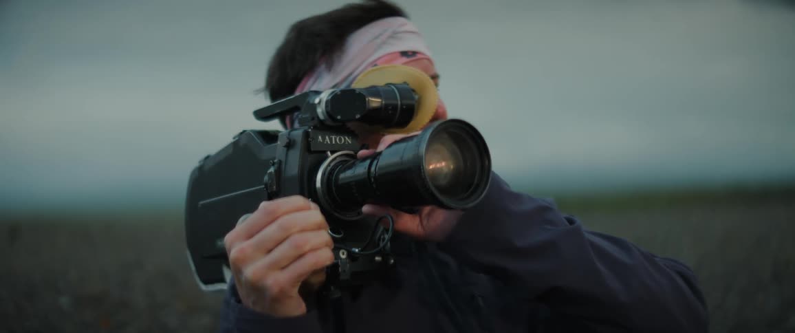 A man is filming something on a field