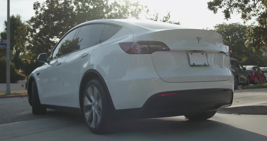 White sports car drives on city street in the neighborhood