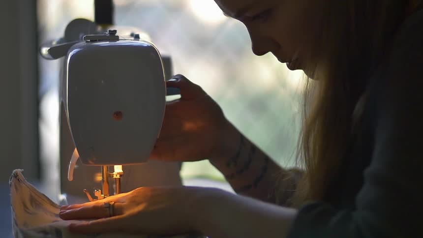 A woman is operating a sewing machine