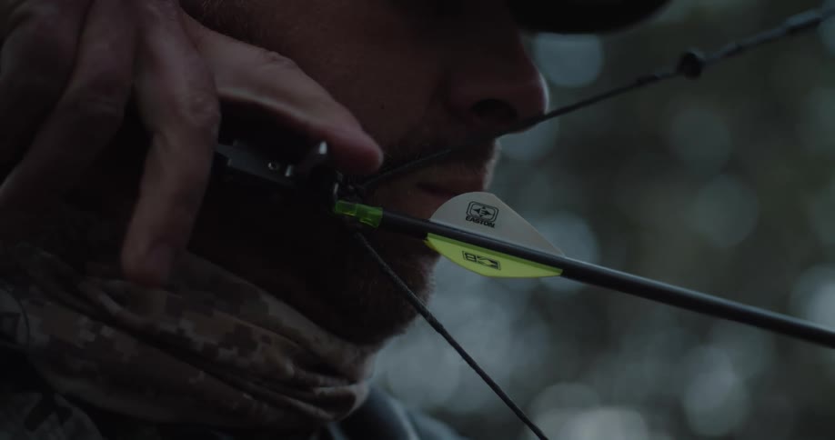 Close up of a man shooting a bow and arrow