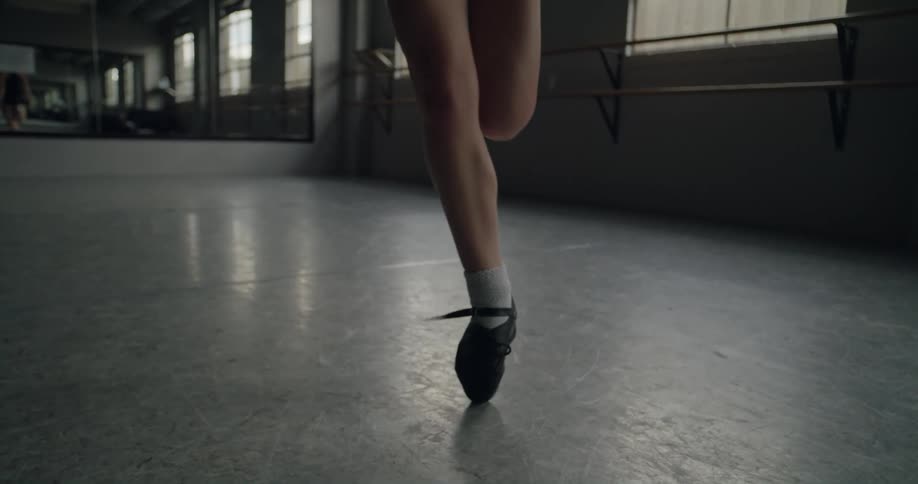 A ballet dancer practices jumping in a dance studio