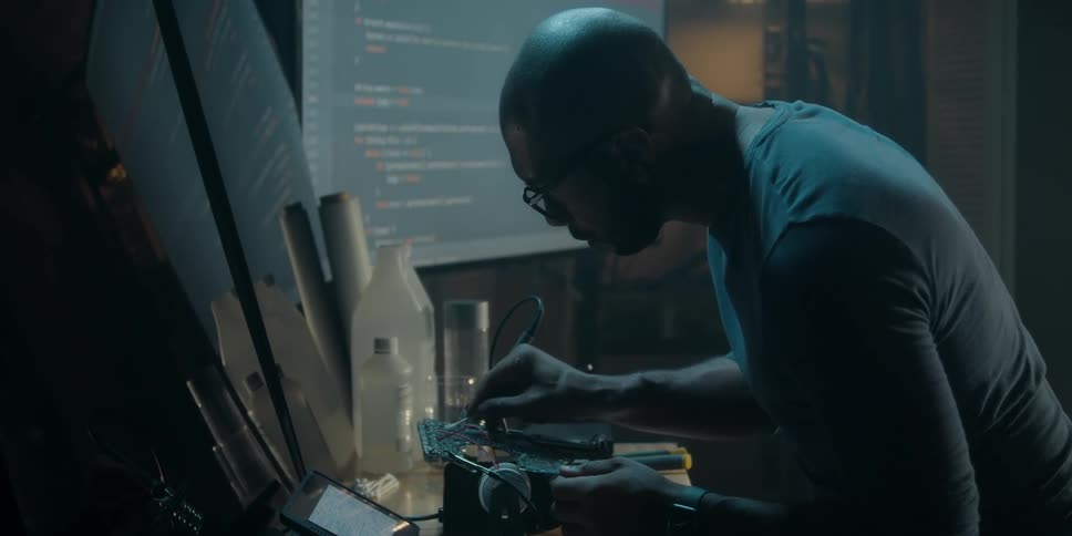A man is cleaning off a motherboard with a cotton swab