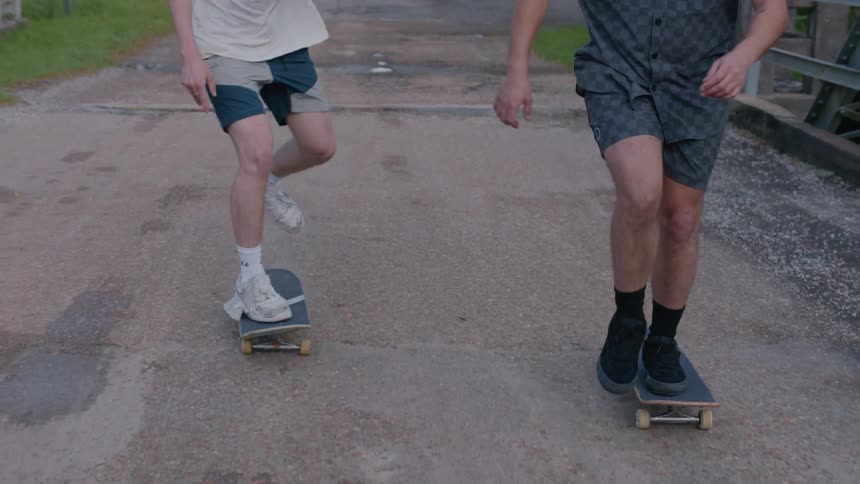 Male skateboarders skateboard over the bridge