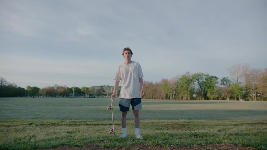 Portrait of a teenage boy standing and holding a skateboard