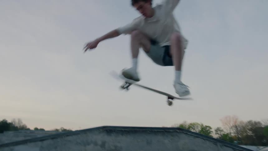 Male skateboarder performs a trick in skatepark
