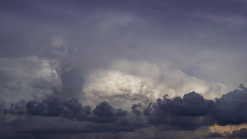 Time lapse of dark storm clouds and cumulous nimbus clouds boil as they move across the sky
