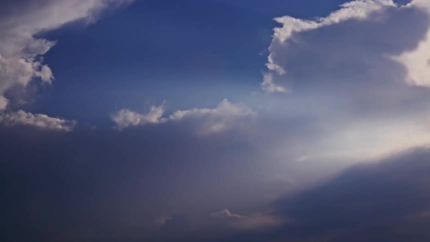 Time Lapse of white cumulus clouds streaking across the hot humid summer sky