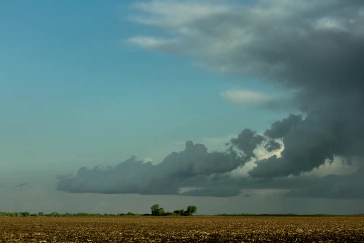 Time lapse of storm clouds moving and dissipating over a field at daytime