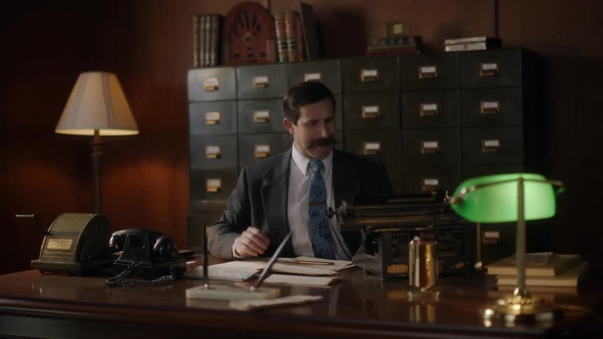 A man is sitting in his office and looking at documents