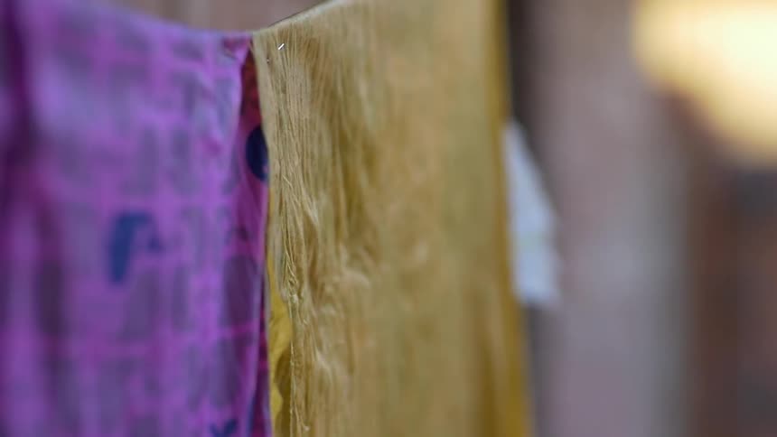 Fabric sheets are hanging from a line