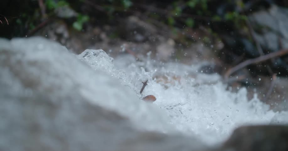 Close up view of water in a stream splashing as it rolls over rocks
