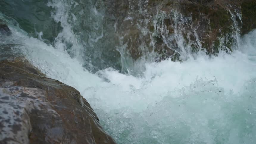 A waterfall rushes into a river