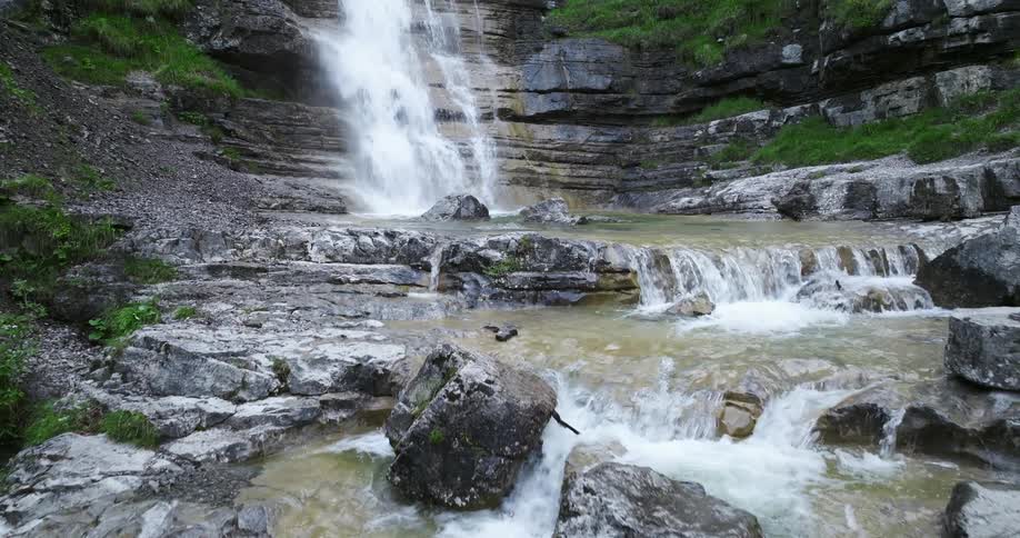 Water falls down cliff then flows further in series of short waterfalls