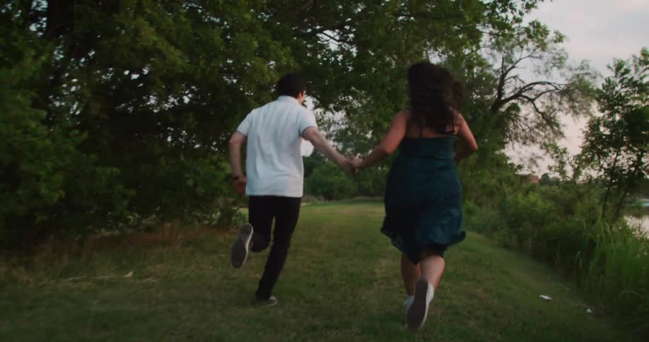 A couple run together while holding hands