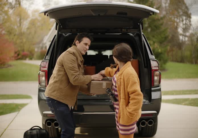 Father and daughter are packing up there car with some luggage